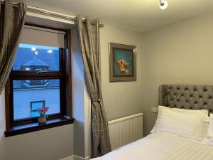 1 dormitorio con cama y ventana en Commercial Hotel (Insch) en Insch