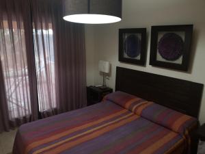 a bedroom with a bed with a colorful striped blanket at Javea: Apartment/ flat - Jávea in Jávea +8 photos