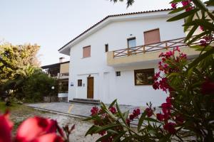 a white house with flowers in front of it at Joseph Village Apartments in Fourka