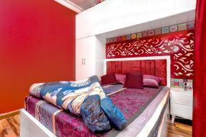 een slaapkamer met een bed met een rode muur bij The View Apartment in Hurghada
