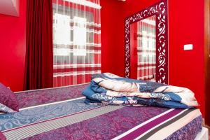 een slaapkamer met rode muren en een bed met een spiegel bij The View Apartment in Hurghada