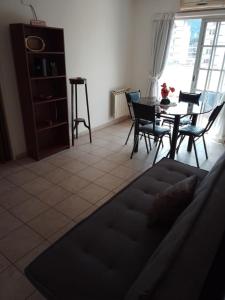 sala de estar con sofá, mesa y sillas en DEPTO BELGRANO en Salta