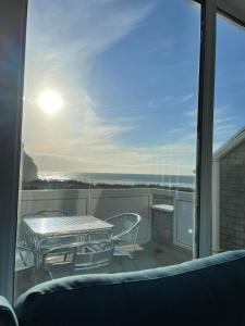 a view of a balcony with a table and chairs at Whispering Waves in Porthtowan @ Cornwall Coastal Holidays in Porthtowan