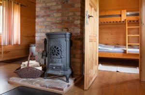 a stove in a room next to a bedroom at Domki Dzika Róża in Darłowo +27 photos