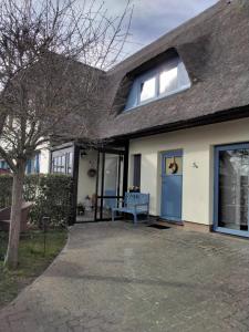 a house with a blue door and a bench at Ferienwohnung im Rohrdachhaus in Wustrow