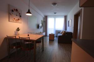 cocina y sala de estar con mesa y sillas en Apartman 13 Vsemina, en Všemina