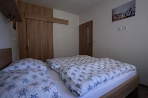 - une chambre dotée d'un lit avec des draps bleus et blancs dans l'établissement Apartman 13 Vsemina, à Všemina