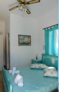 sypialnia z niebieskim łóżkiem i wentylatorem sufitowym w obiekcie Yacht Front Studio-Back Yard - No 6 w mieście Ios (Chora)