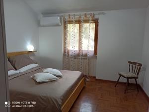 ein Schlafzimmer mit einem Bett, einem Stuhl und einem Fenster in der Unterkunft Bed & Breakfast Le cicale e la formica in Casarza Ligure