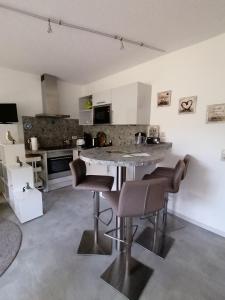 een keuken met een tafel en stoelen in een kamer bij Ferienwohnung Auszeit Parkresidenz in Hahnenklee-Bockswiese