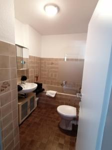 y baño con aseo blanco y lavamanos. en Ferienwohnung Auszeit Parkresidenz, en Hahnenklee-Bockswiese