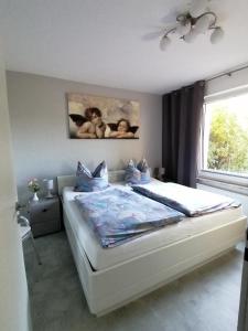 1 dormitorio con 1 cama con 2 bebés colgando en la pared en Ferienwohnung Auszeit Parkresidenz, en Hahnenklee-Bockswiese