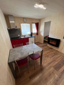 a kitchen and dining room with a table and chairs at Bungalow Miralago in Camping Cavresc, Via dal Cavresc 1, 7746 Le Prese-Poschiavo in Poschiavo