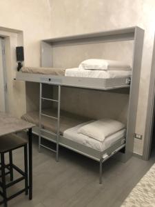 Zimmer mit 2 Etagenbetten und einem Tisch in der Unterkunft La Casetta di Lulù in Neapel
