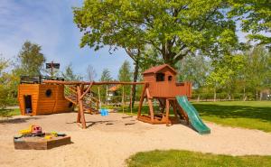 a playground with a slide and a play house at Domki Dzika Róża in Darłowo