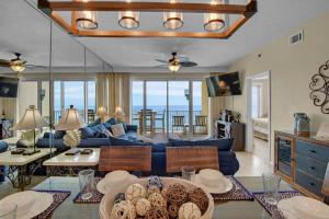 uma sala de estar com um sofá azul e uma mesa em Leeward Key 905- Suite Sea-Cret em Destin