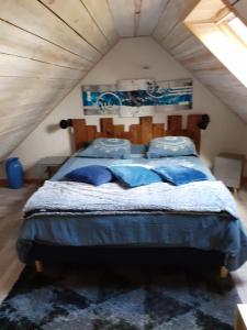 um quarto com uma cama grande e almofadas azuis em Penandaouent em Commana