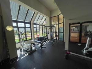 a gym with cardio equipment in a room with windows at Adara YourHostHelper in Caen