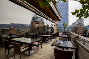 a restaurant with tables and chairs on the roof of a building at Plaza El Bosque Ebro in Santiago