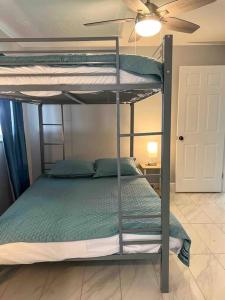 two bunk beds in a room with a ceiling fan at House of Manatees-Entire house with yard, fire pit, dog friendly in Crystal River +40 photos