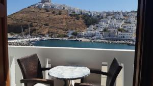 a table and chairs on a balcony with a view of a harbor at Ενάλιον in Astypalaia