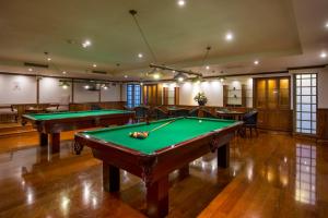 a billiard room with two pool tables and chairs at Plaza El Bosque Ebro in Santiago