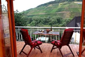 a table and two chairs on a deck with a view at Casa Barzen - Stilvoll Urlauben an der Mosel in Reil