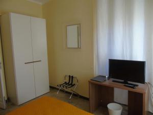 Habitación con escritorio, ordenador y TV. en Affittacamere Bel Sole, en Borghetto di Vara