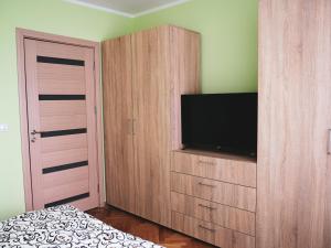 a bedroom with a entertainment center with a flat screen tv at Modern Room With A Great Sunrise - close to the center - in Timişoara