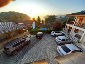 tres autos estacionados en un estacionamiento frente a una casa en Pousada dos Navegantes, en Paraty