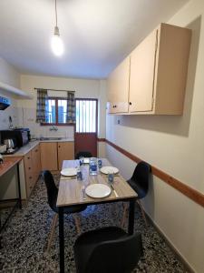 - une cuisine avec une table et des chaises dans la chambre dans l'établissement Family apartment with 2 bedrooms to the city center, à Kamena Vourla