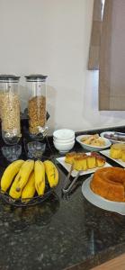 a table topped with plates of bananas and other food at HOTEL SAYMON in Cafelândia
