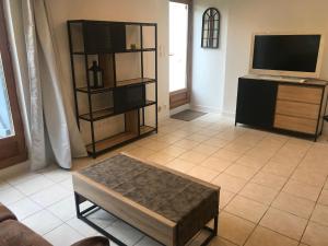 a living room with a tv and a coffee table at Gite Factory - T2 de 51m2 5 min centre ville Bergerac - Les Bergeronnettes in Bergerac