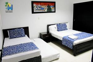 1 dormitorio con 2 camas y una foto en la pared en Hotel Medellin, en Santa Marta