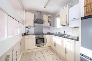 a kitchen with white cabinets and a sink at 1-double bedroom aparment in Central London in London