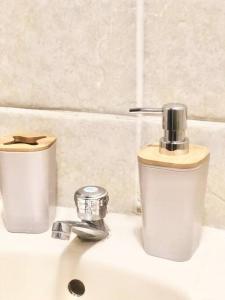 a bathroom sink with two soap dispensers on it at Exclusivo y acogedor con ascensor Directo en Urbanización la Merced in Trujillo