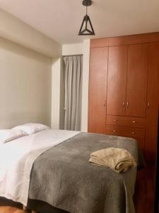 a bedroom with a large bed with a dresser and a bed sidx sidx sidx at Exclusivo y acogedor con ascensor Directo en Urbanización la Merced in Trujillo