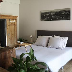 1 dormitorio con 1 cama con sábanas blancas y mesa en Bed and Breakfast 'Wij en de Zande' - kamer deluxe en Kamperveen