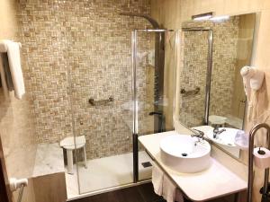 a bathroom with a glass shower and a sink at Hotel Playa de Lago in Muxia