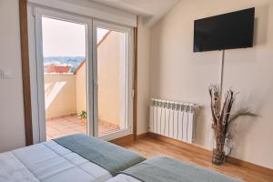 a bedroom with a bed and a large window at Pensión A Solaina 3 in O Pedrouzo