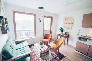 un soggiorno con divano e sedie e una cucina di FURU Hostel & Café a Bøstad
