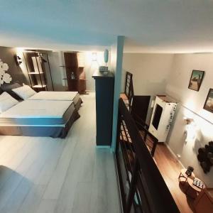 um quarto com uma cama e uma televisão em Charmant Studio en duplex esprit loft avec balcon vue mer, et piscine extérieure em Le Croisic