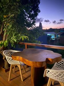 a wooden table and chairs on a deck with a view at Pousada da Mana in Fernando de Noronha