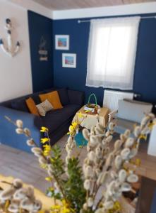 uma sala de estar com paredes azuis e um sofá azul em Cztery Pory Warmii Pluski pokoje do wynajęcia em Pluski