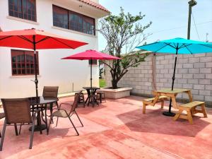 un patio avec des tables, des chaises et des parasols dans l'établissement VILLAZOL CABAÑAS, à Zacatlán