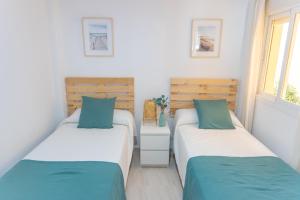 two twin beds in a room with a window at Duplex Sereno 7 - Piscina, Garaje, Jardín y Playa in Los Caños de Meca