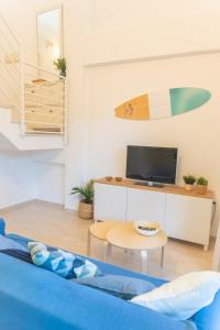 uma sala de estar com uma prancha de surf na parede em Duplex Sereno 7 - Piscina, Garaje, Jardín y Playa em Los Caños de Meca