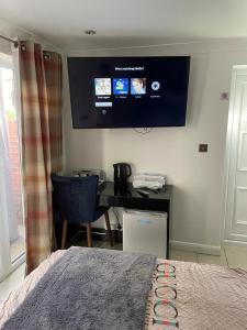 a bedroom with a desk and a tv on the wall at Travel Legend Stays 1 or 2 bedroom place with Hot Tub in Farnham Royal