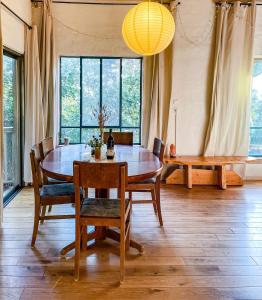 a dining room with a table and chairs and a chandelier at THE HOUSE IN THE OAKS הבית באלונים in Amirim