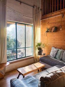 - un salon avec un canapé, une table et une fenêtre dans l'établissement THE HOUSE IN THE OAKS הבית באלונים, à Amirim